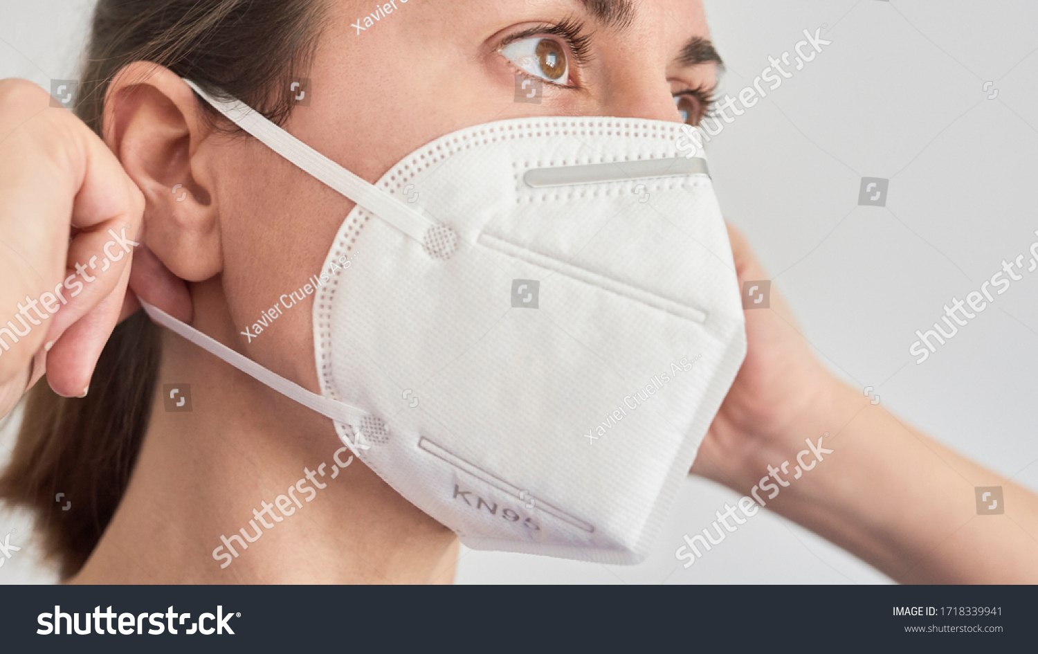 Close up picture of a brunette woman wearing a KN95 FPP2 mask. #1718339941