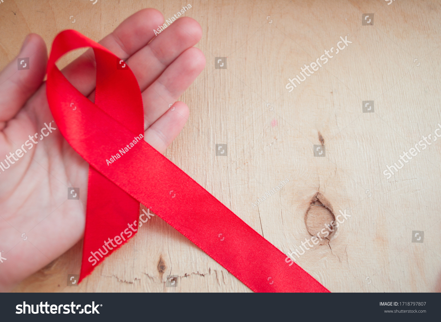 hand holds red awareness ribbon, world aids day, aids awareness ribbon. #1718797807