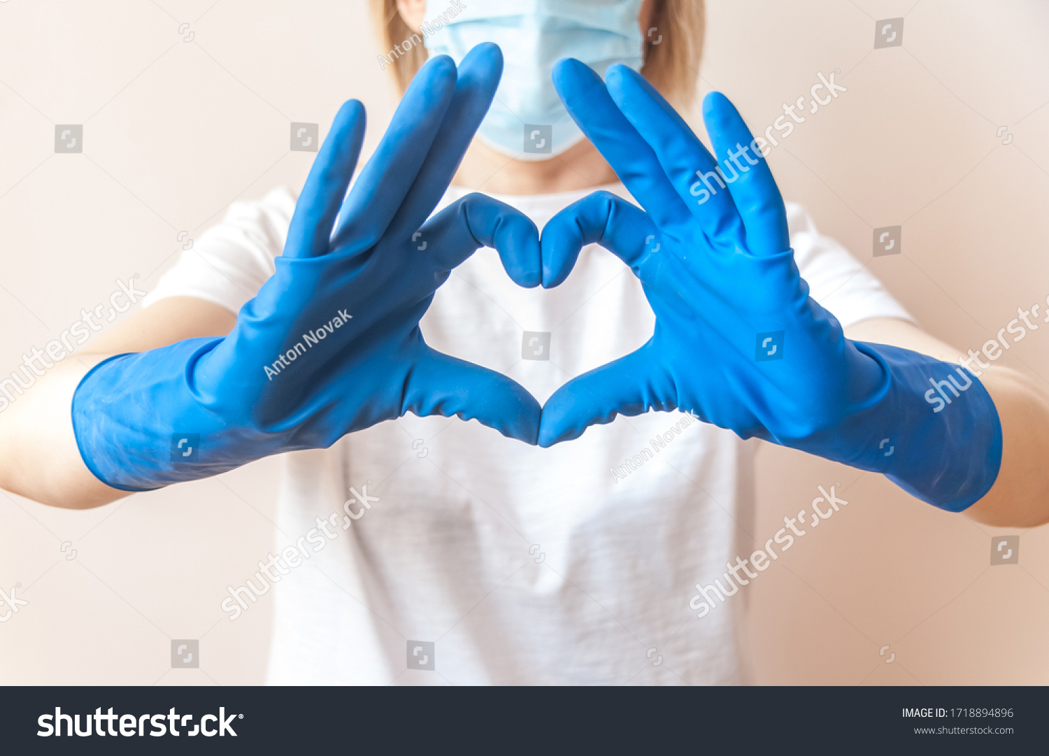 Nurse doctor hands in blue medical gloves in the shape of heart against the background of her body. Close up. Blurred background. Thanks to health workers concept. Gratitude to the medical staff. #1718894896