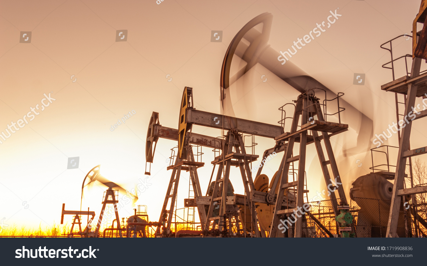 Oil pump rig. Oil and gas production. Oilfield site. Pump Jack are running. Drilling derricks for fossil fuels output and crude oil production. War on oil prices. Global coronavirus COVID 19 crisis. #1719908836