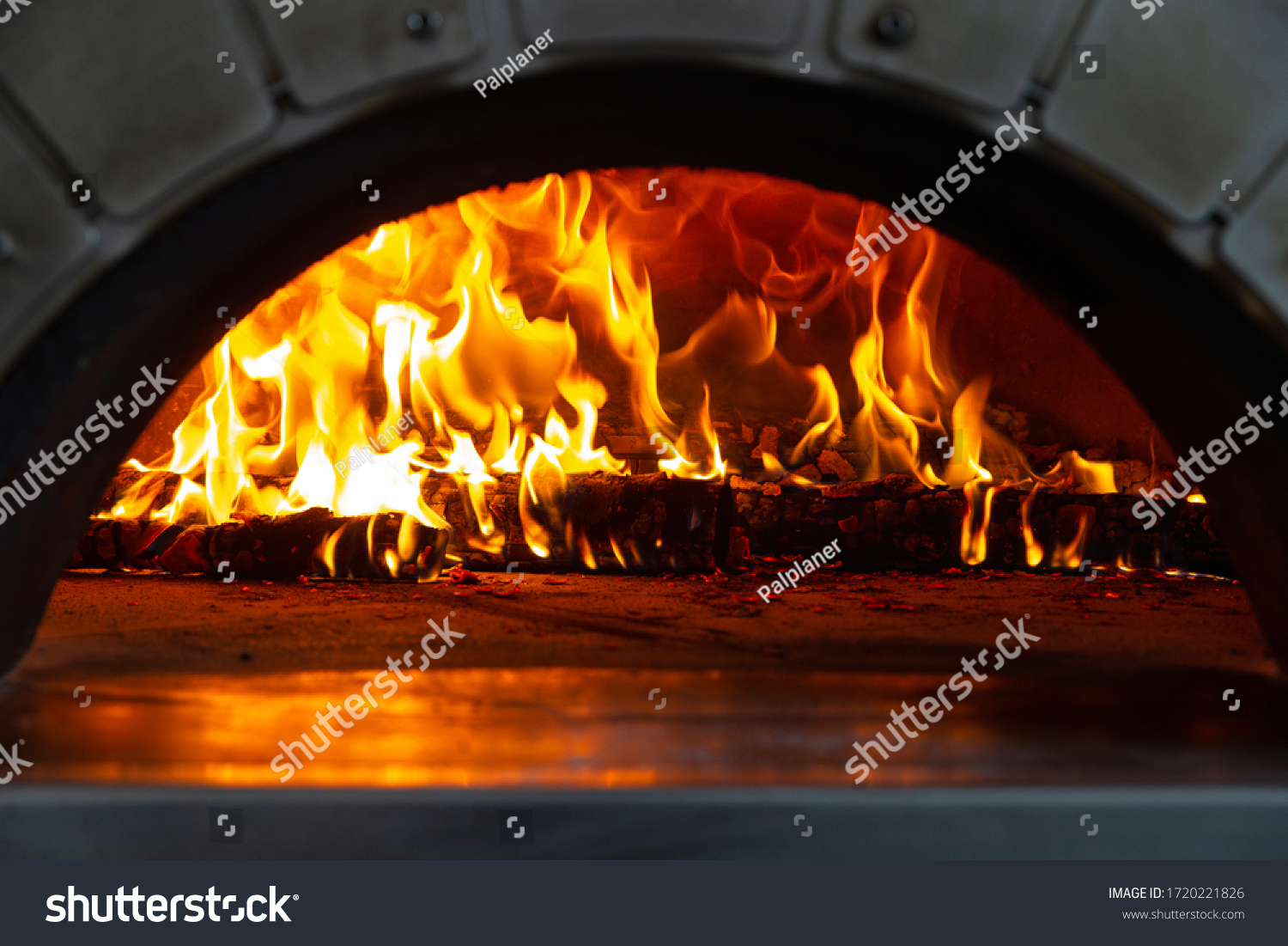 A fire is burning in a pizza oven. selective focus #1720221826