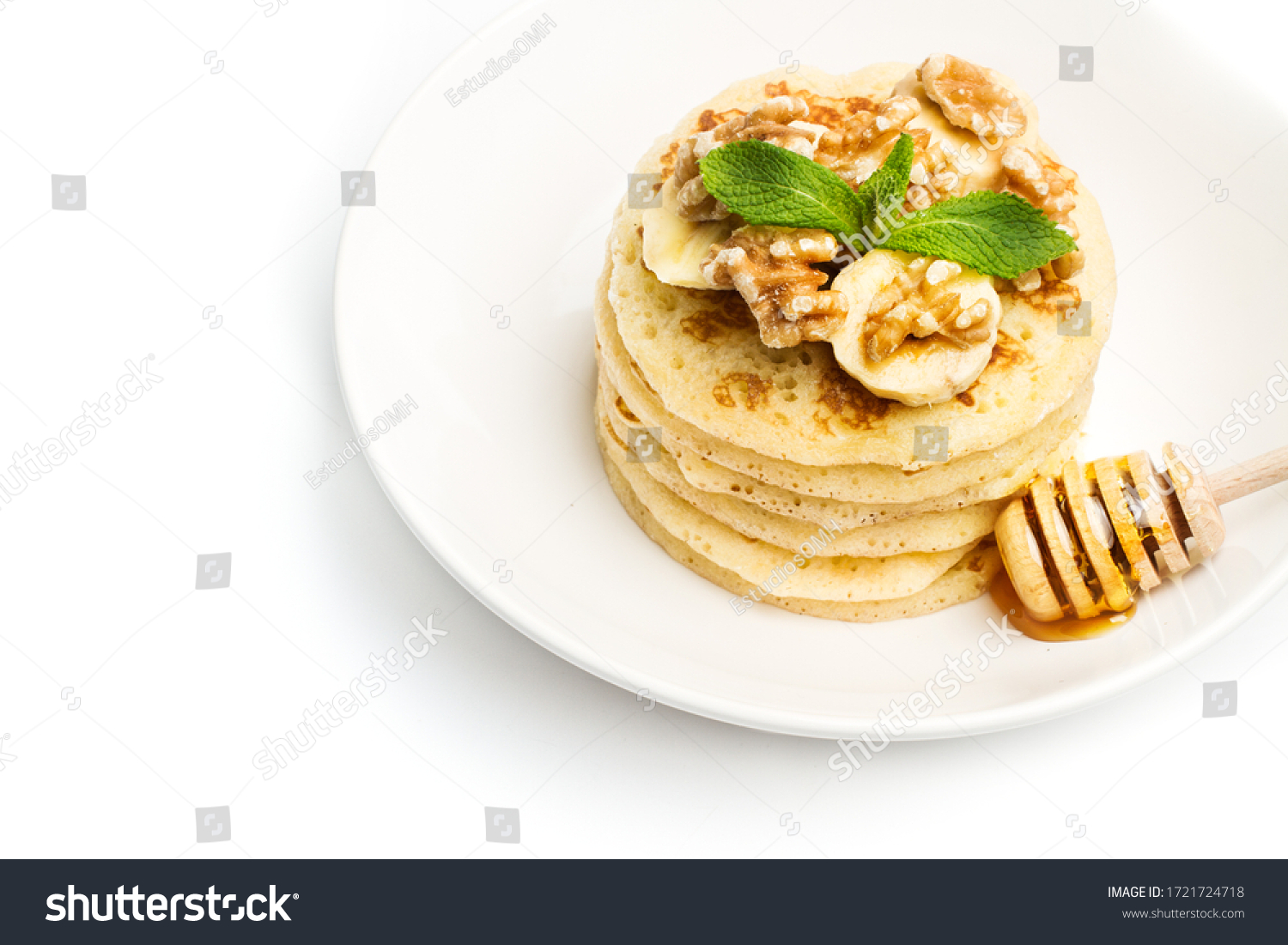 Pancakes with banana slices on a white plate #1721724718