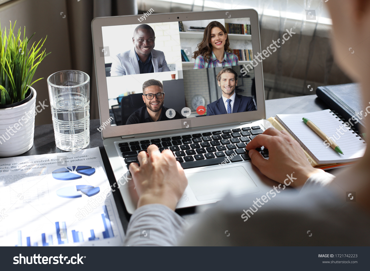 Business woman talking to her colleagues in video conference. Multiethnic business team working from home using laptop. #1721742223