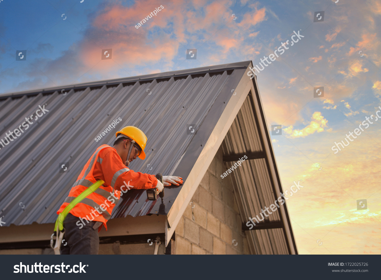 Roofer Construction worker install new roof,Roofing tools,Electric drill used on new roofs with Metal Sheet. #1722025726