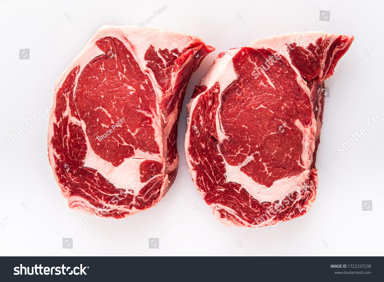 Two freshly cut boneless ribeye steaks on a butchers table #1722297238