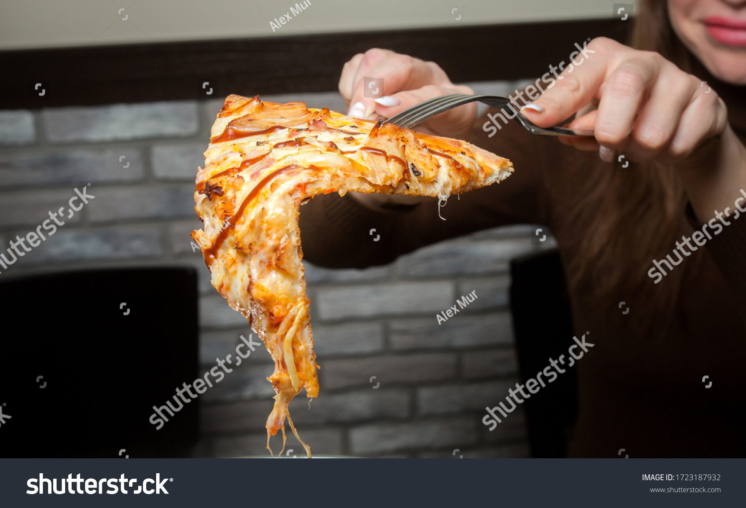 The girl takes a slice of pizza with a fork and knife #1723187932
