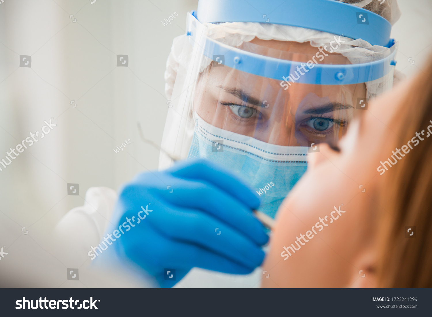 Young female dentist curing patient's teeth filling cavity. Stomatologist working with professional equipment in clinic office. Close-up shot, teeth care and medicine concept #1723241299