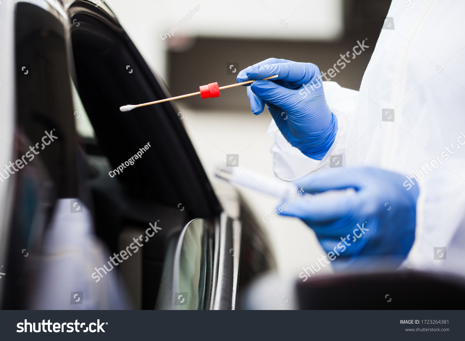 Medical worker wearing personal PPE surgical gloves and protective clothing,holding nasal swab,performing drive-thru COVID-19 testing,point of care on site location for PCR detection of Coronavirus  #1723264381