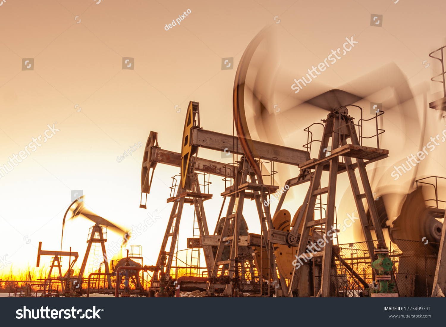 Oil pump rig. Oil and gas production. Oilfield site. Pump Jack are running. Drilling derricks for fossil fuels output and crude oil production. War on oil prices. Global coronavirus COVID 19 crisis. #1723499791