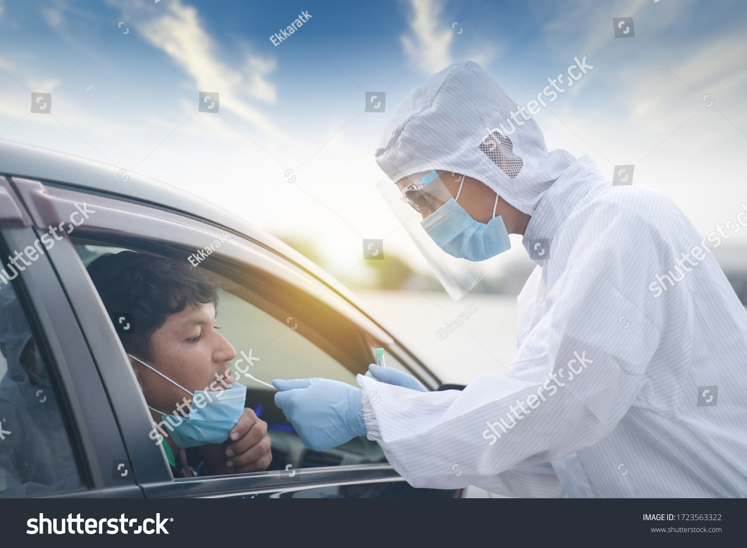 Medical worker in protective suit screening driver to sampling secretion to check for Covid-19. Drive thru test coronavirus fast track. Concept prevention coronavirus outbreak. #1723563322