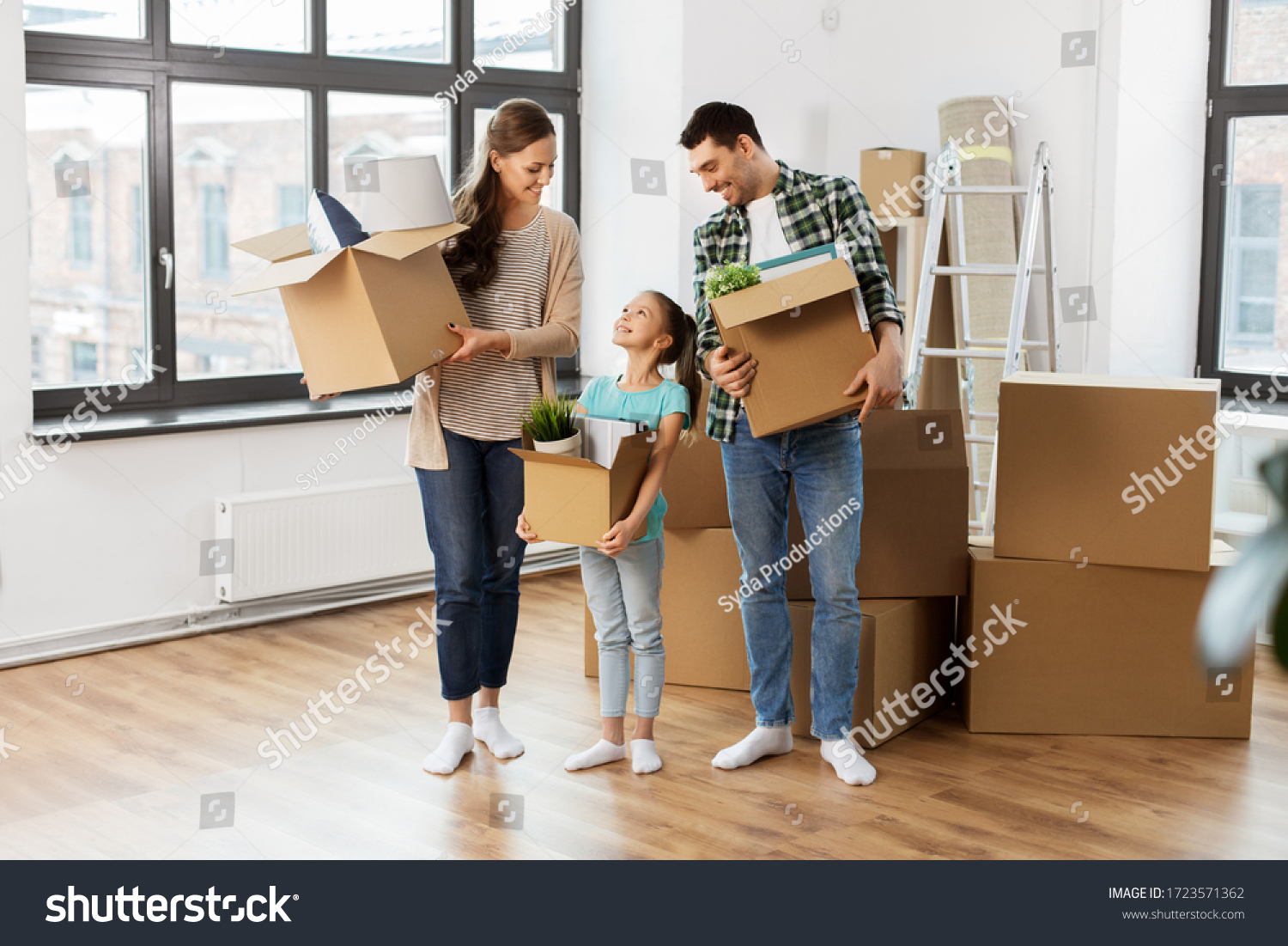 mortgage, family and real estate concept - happy mother, father and little daughter with stuff in boxes moving to new home #1723571362