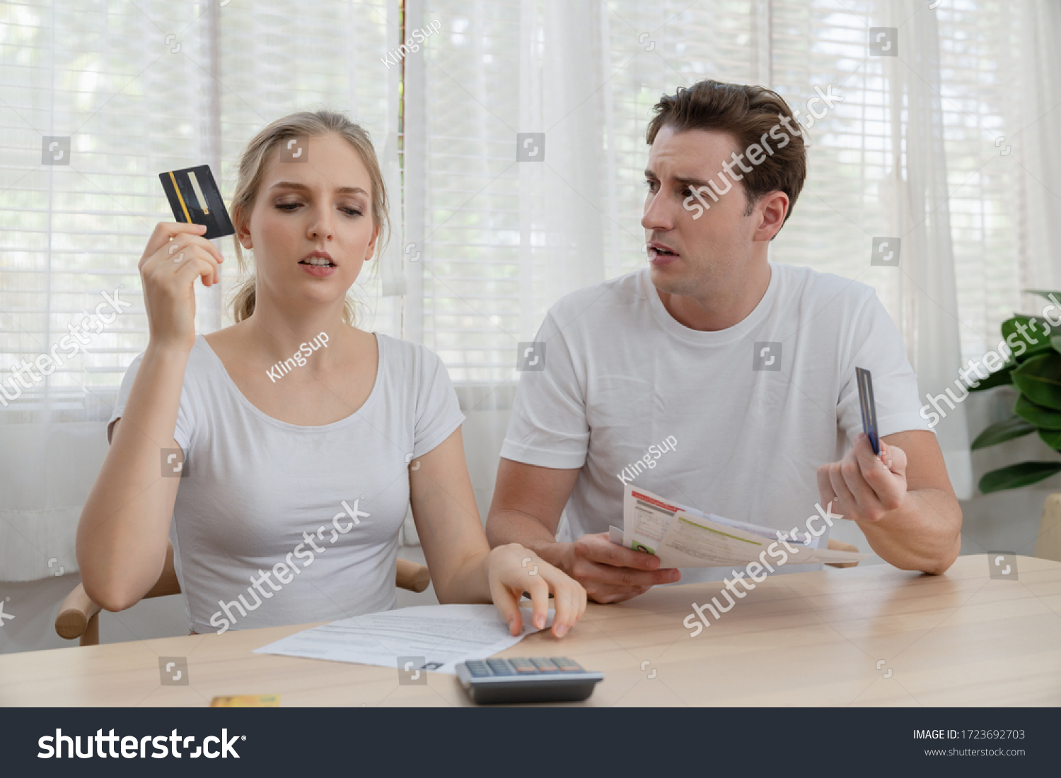 Stressed couple young family holding credit card for pay to so many expenses bills such as electricity bill,
water bill,internet bill,cell phone bill and credit card bill at home #1723692703
