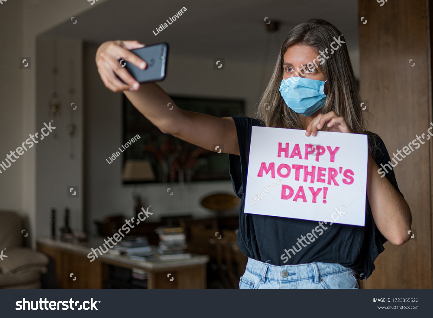 Blonde girl wearing a mask is taking a selfie for mother's day during COVID-19. #1723855522