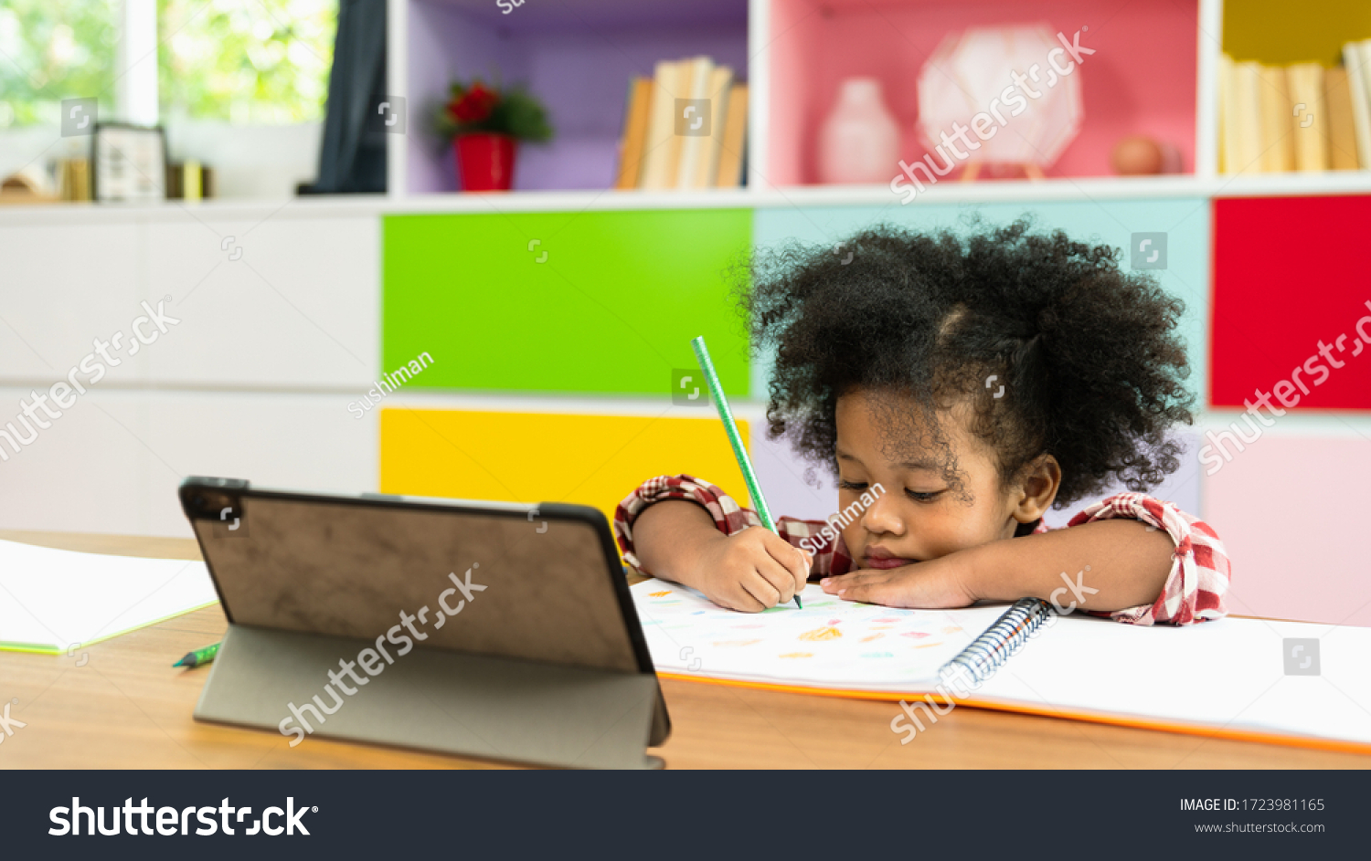 Young African American kid girl studying using digital tablet, preschool child study at home school. Children education, self isolation, coronavirus outbreak social distancing or homeschooling concept #1723981165