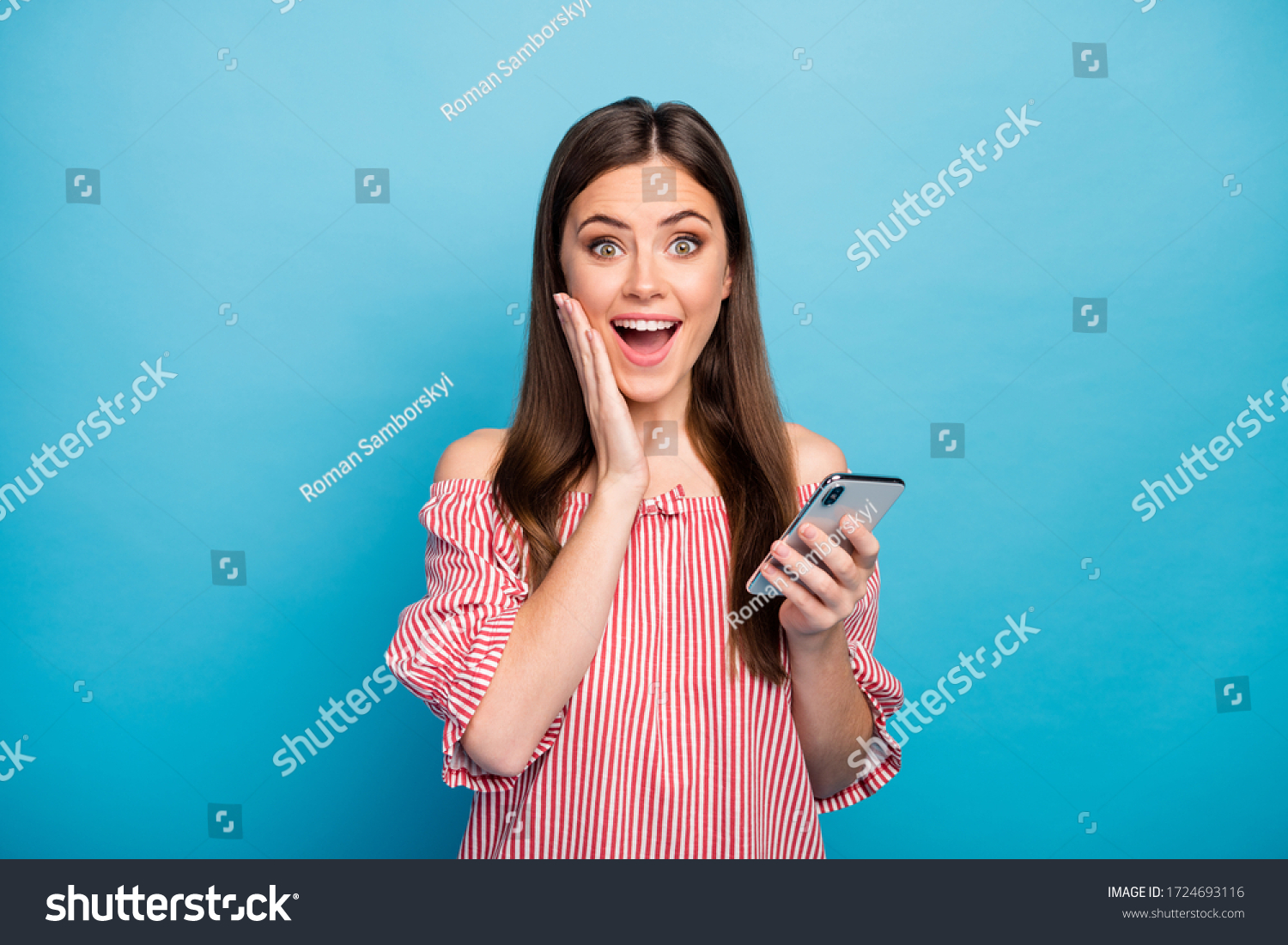 Close-up portrait of her she nice attractive lovely pretty amazed cheerful cheery girl using cell browsing fast speed connection isolated over bright vivid shine vibrant blue color background #1724693116