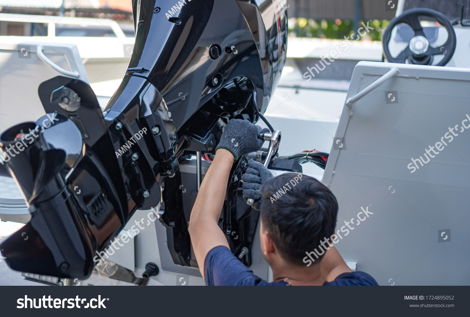 Mechanic is installing speed boat engine , a new engine on an aluminum boat. #1724895052