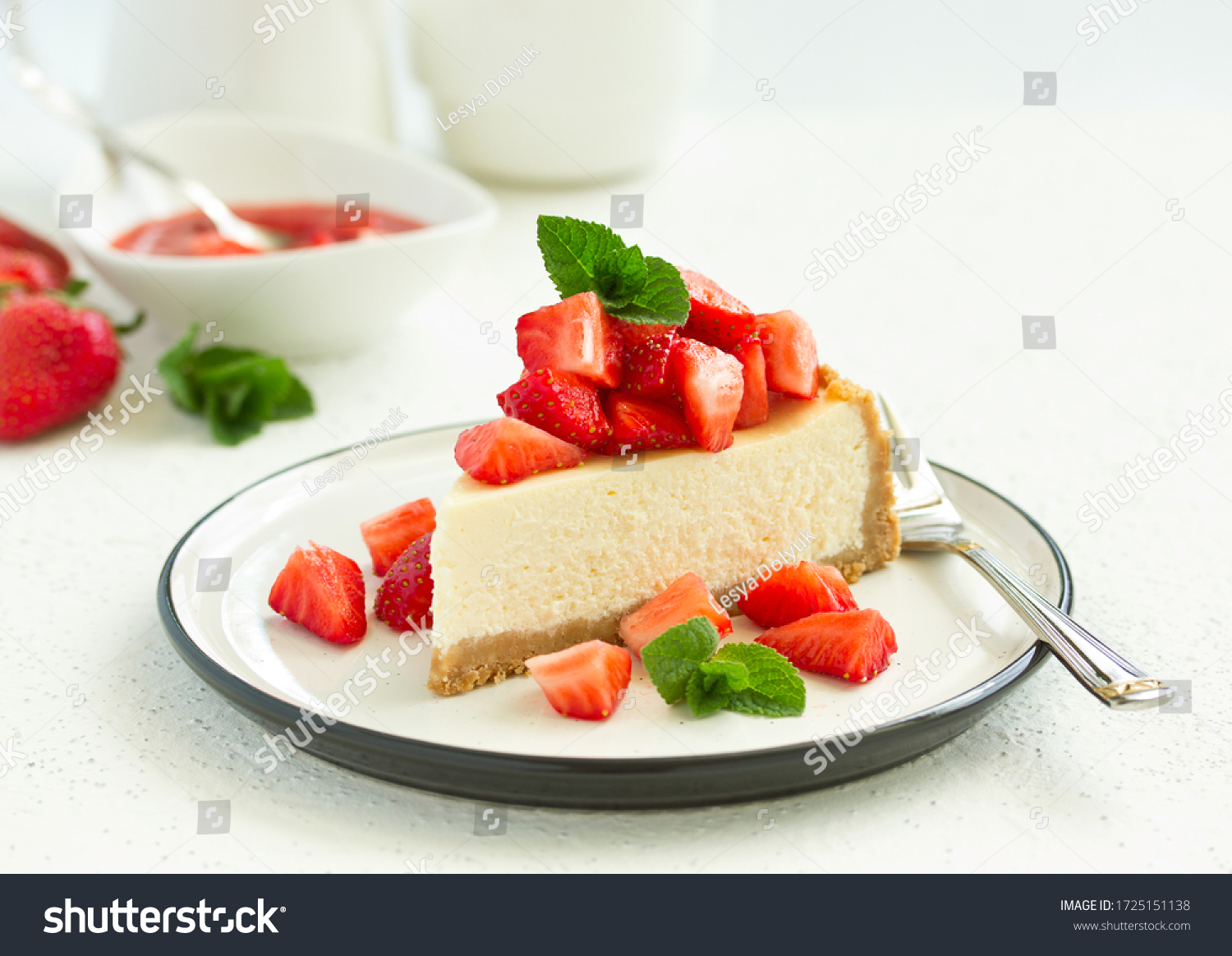 Slice of cheesecake with strawberries, mint and sauce. Selective focus #1725151138