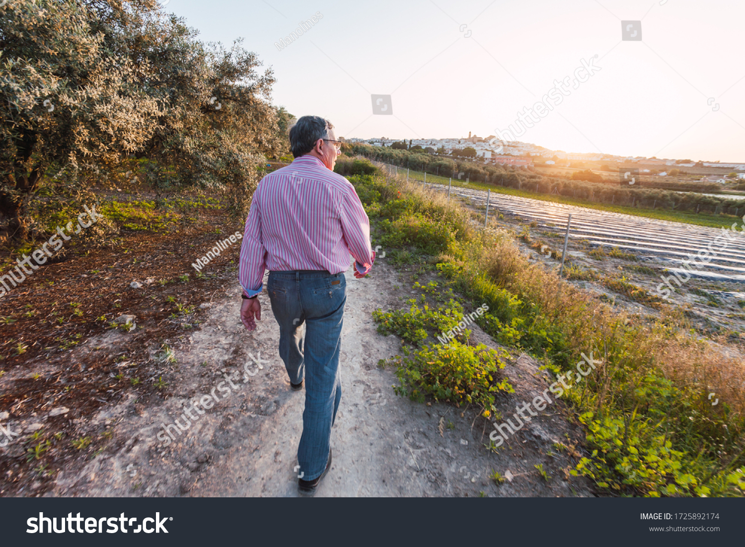 Older man walks alone on the street after being confined by coronavirus. Blurred edges. #1725892174
