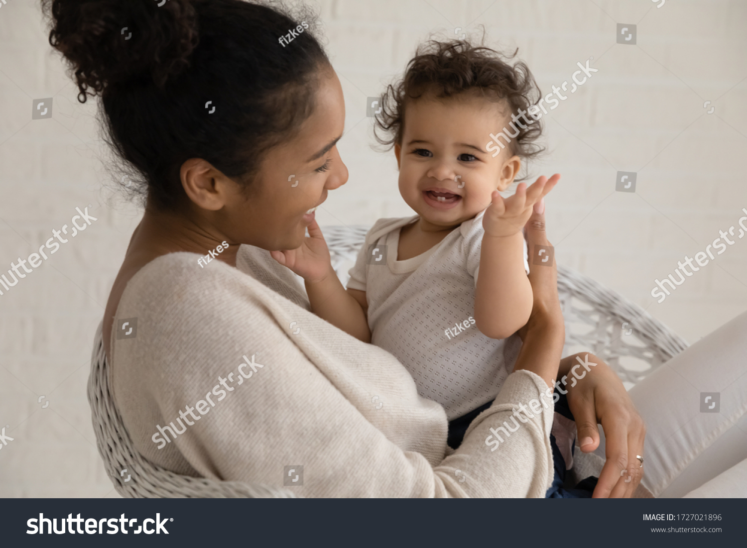 Loving young african American mother hold embrace cute little ethnic infant toddler, caring biracial mom play have fun hug small baby child, enjoy family time at home together, childcare concept #1727021896