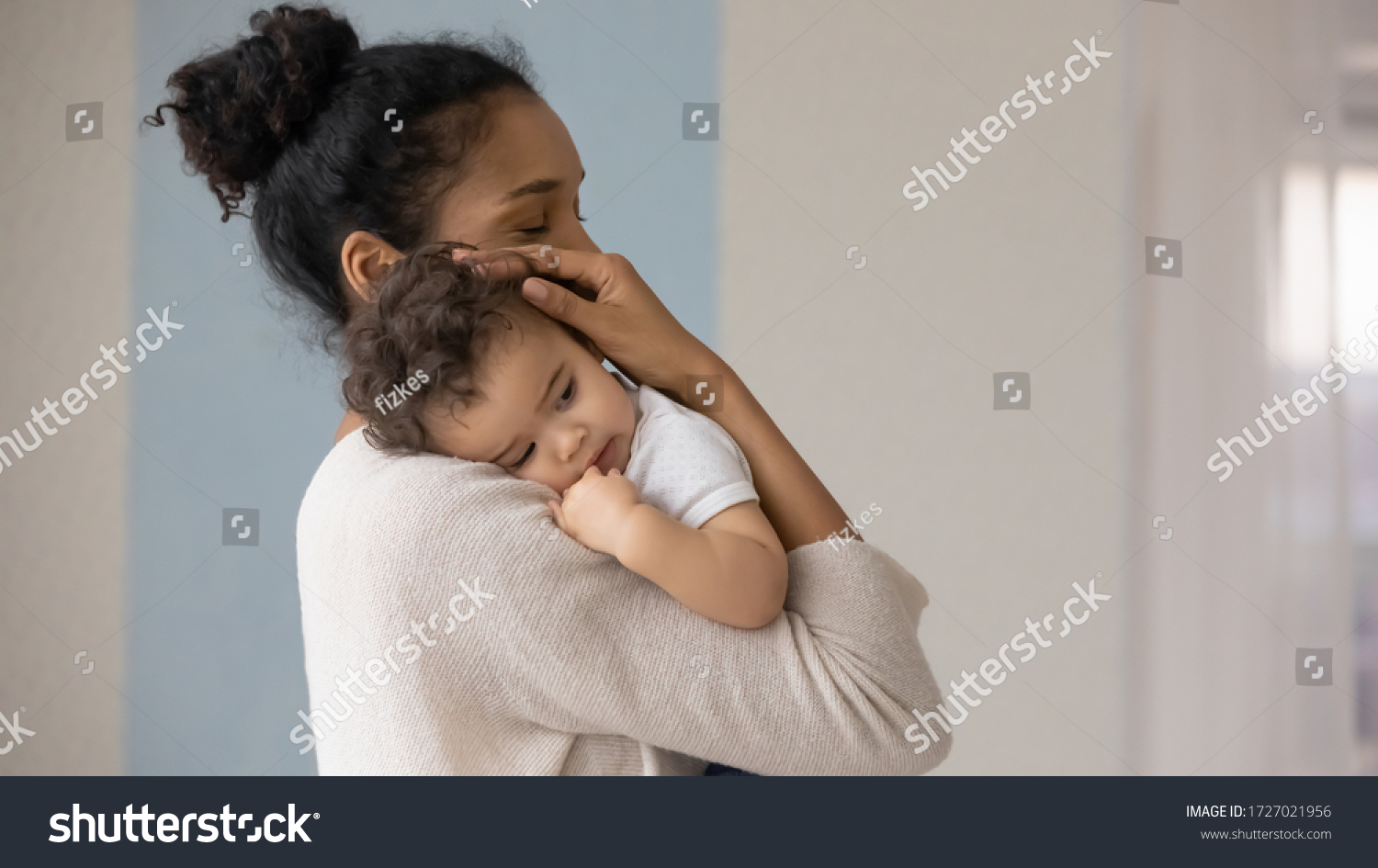 Caring young biracial mother hold lean to chest cute little infant toddler, loving african American mom hug embrace small baby child, relax enjoy tender family moment at home, childcare concept #1727021956