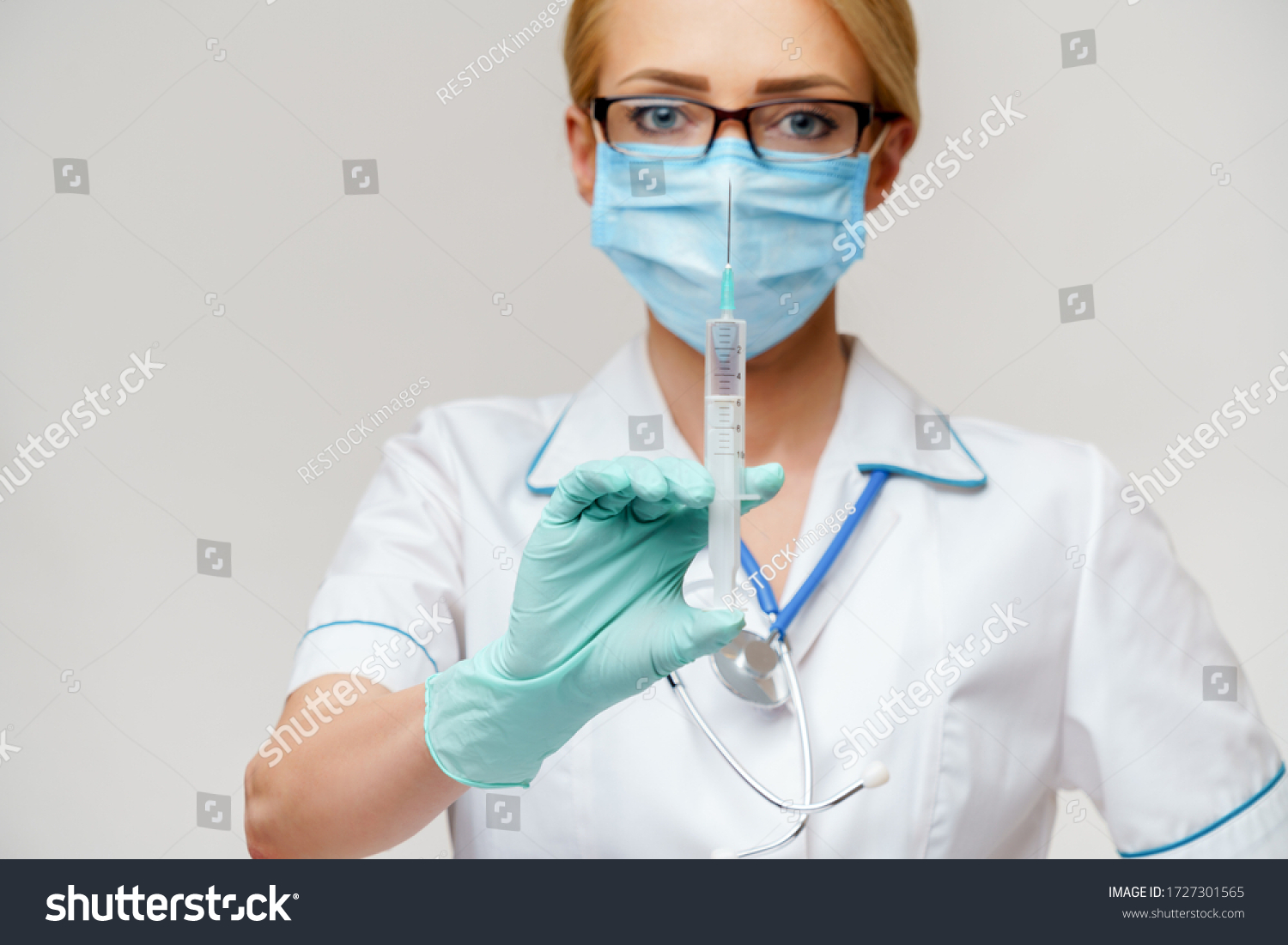medical doctor nurse woman wearing protective mask and gloves - holding syringe #1727301565