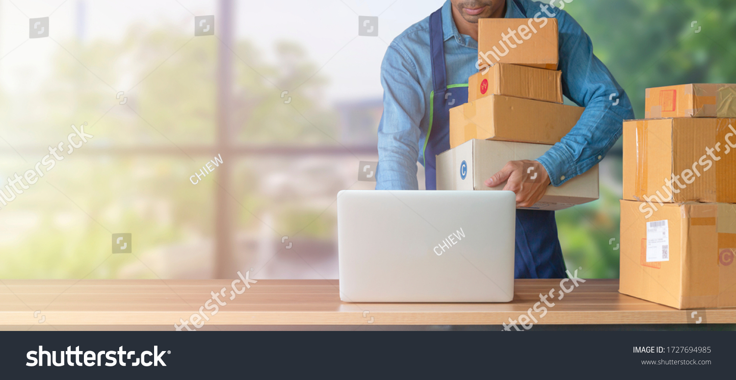 Young start up small business owner writing address on cardboard box at workplace.small business entrepreneur SME , working with box at home, Online selling, e-commerce, packing concept #1727694985