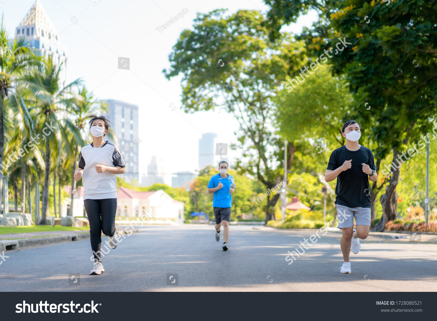 Asian young three woman and man are jogging and exciseing outdoor in city park and wearing protective mask on face for stay in fit during Covid-19 pandemic in Bangkok, Thailand.
 #1728080521