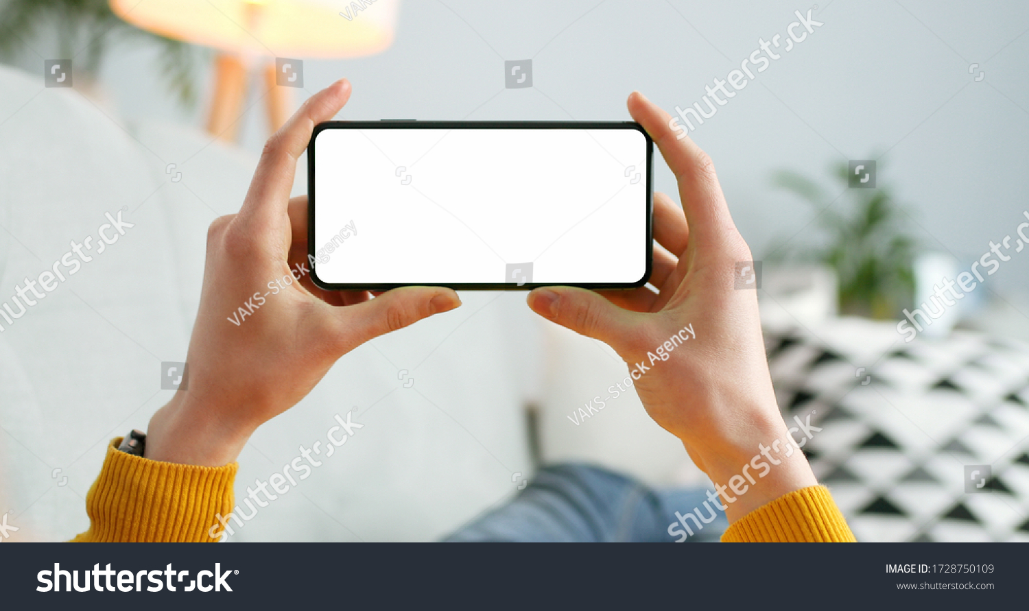 Close up of horizontal black smartphone with blank screen in woman hands. Mobile phone with blank copy space screen for your text #1728750109