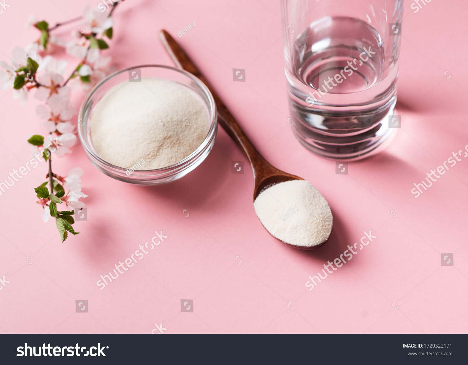 Collagen powder in wooden spoon, supplement with galss of water and flowers, healthy and anti age concept  on pink background, top view, copy space #1729322191