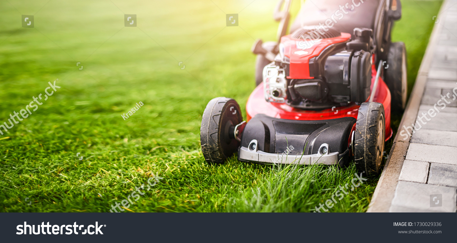 Lawn mover on green grass in modern garden. Machine for cutting lawns. #1730029336
