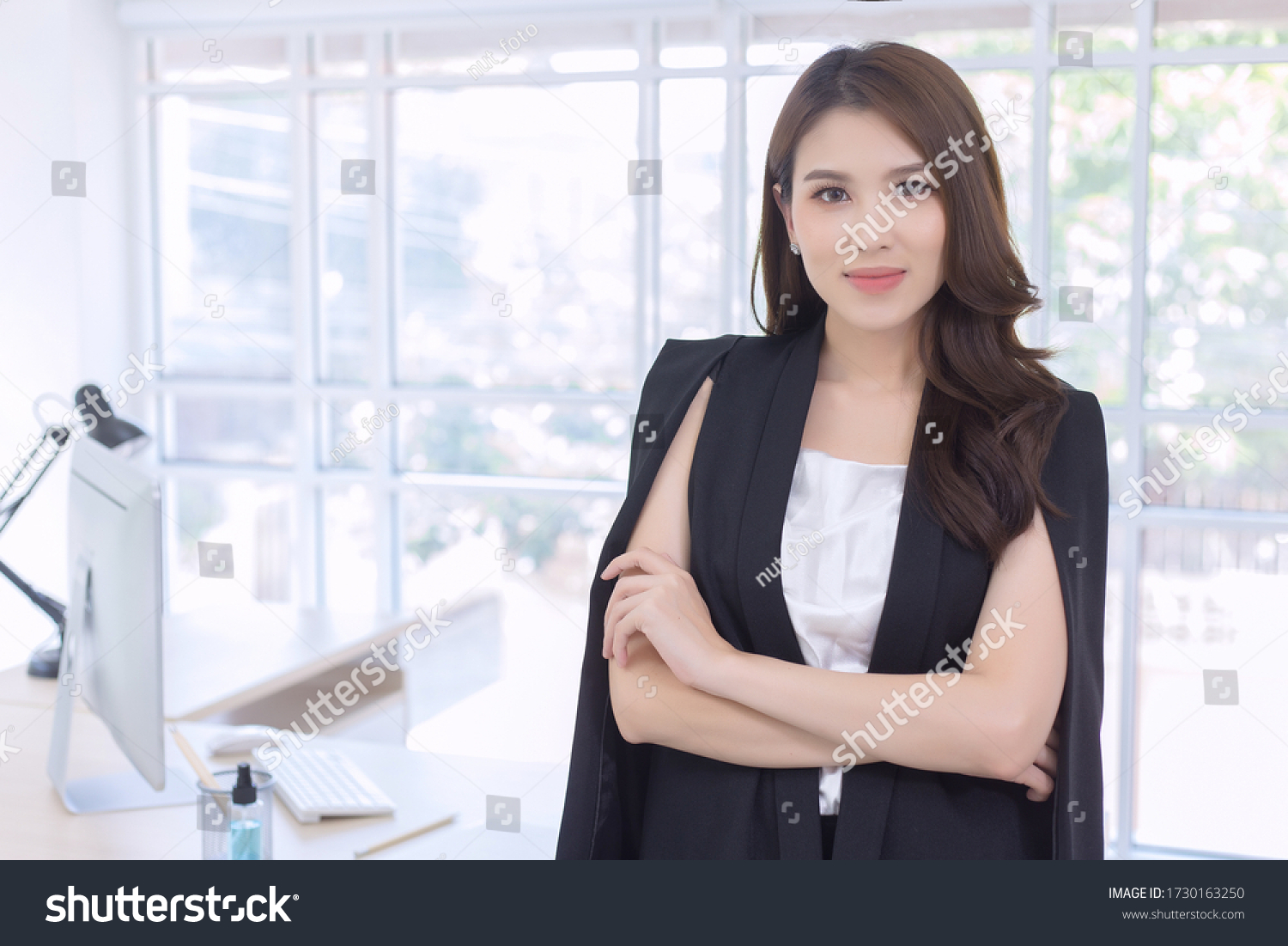 Work from home. Beautiful office lady standing and smiling at work happily. #1730163250