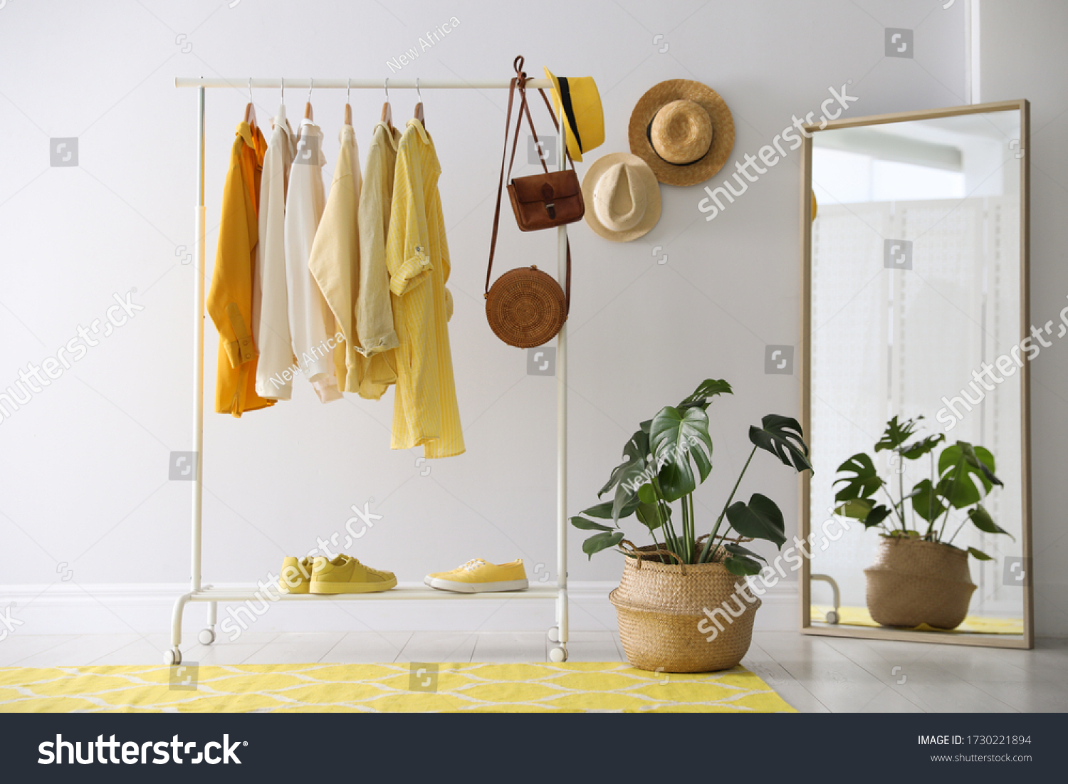 Rack with stylish women's clothes and mirror indoors. Interior design #1730221894
