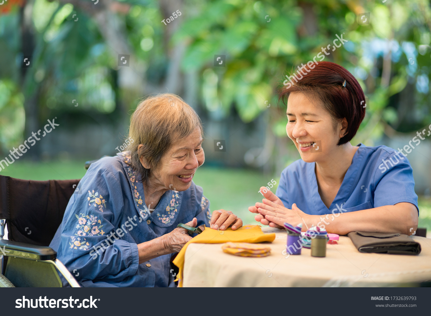 Elderly woman with caregiver in the needle crafts occupational therapy  for Alzheimer’s or dementia #1732639793