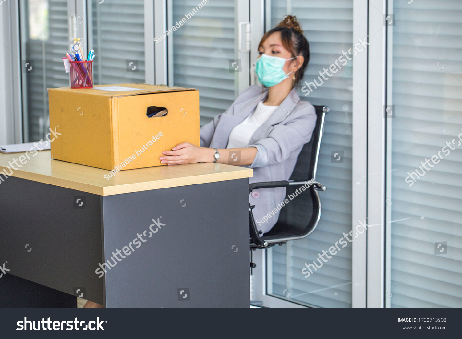 Asian women wear medical masks, store belongings after being laid off due to covid 19 disease Outbreak caused bankruptcy.Lay off and the economy concept. #1732713908