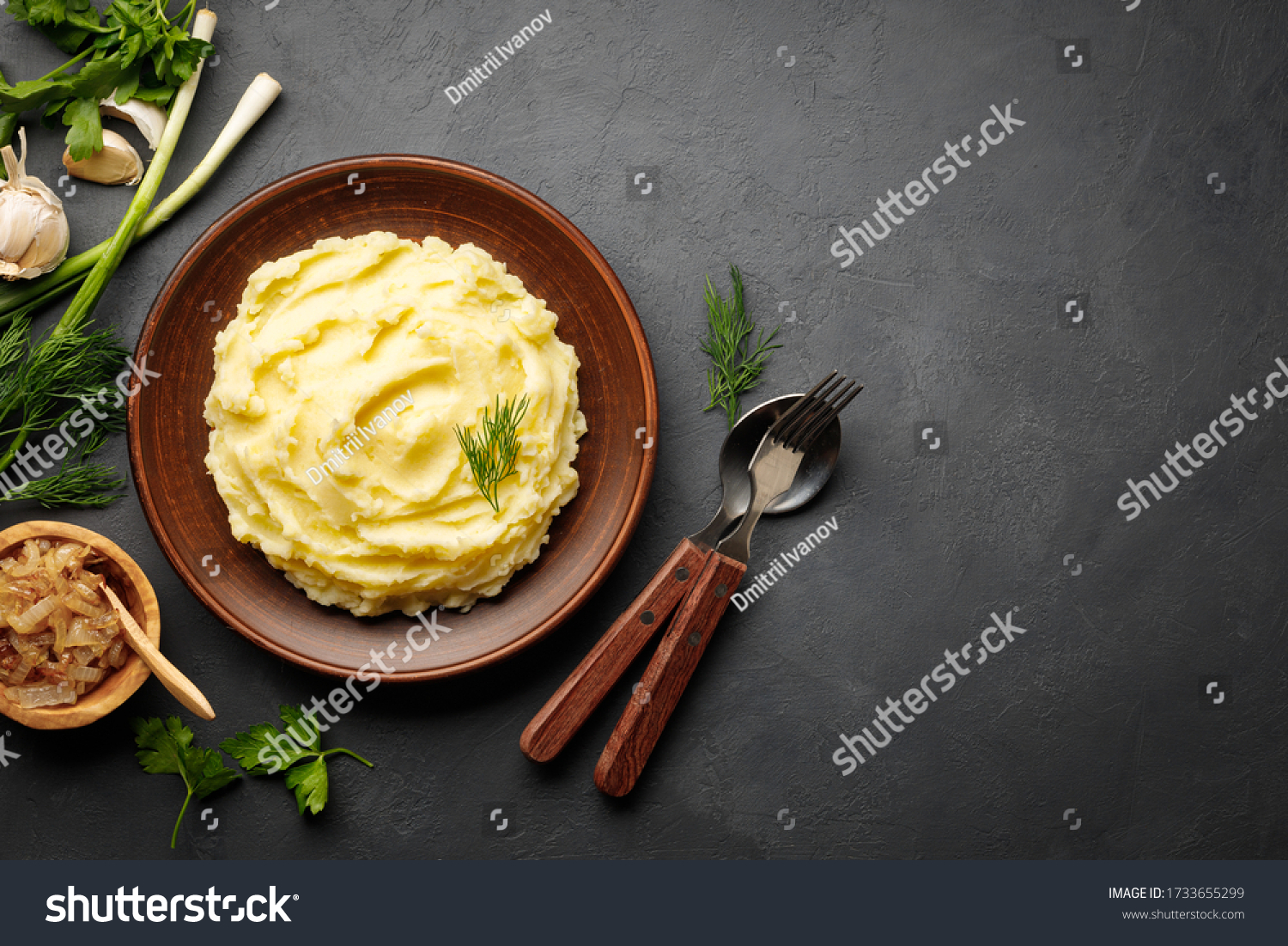 Mashed potatoes, boiled puree in a brown plate on a black slate background. Top view. Flat lay. Copy space. #1733655299