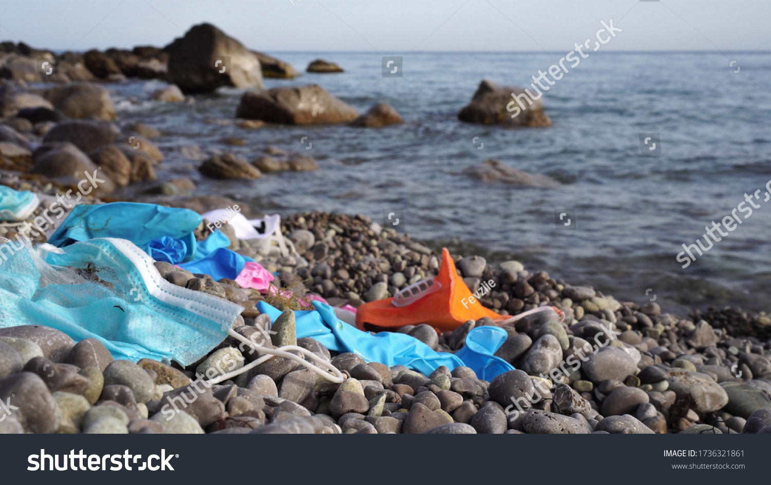 Waste during COVID-19. Discarded to ocean coronavirus single-use face masks and usesd latex gloves. Environmental and ocean plastic pollution #1736321861