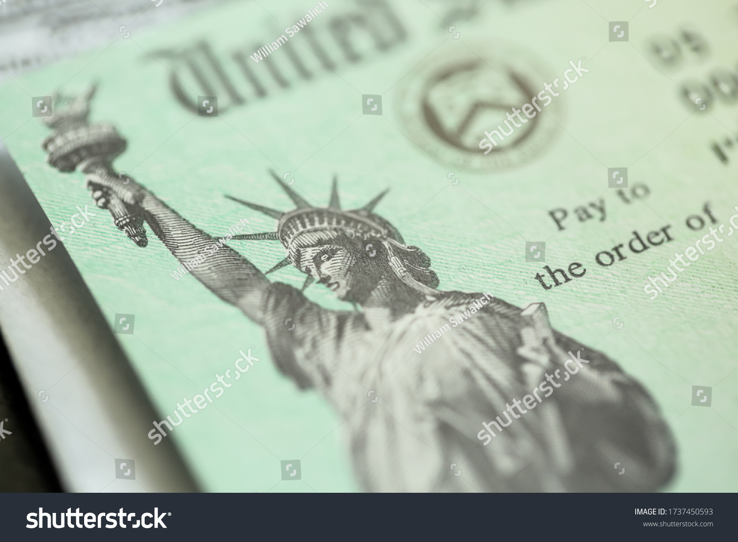 Extreme close-up of Federal coronavirus stimulus check provided to all Americans from the United States Treasury in 2020 and 2021, showing the statue of liberty.  #1737450593