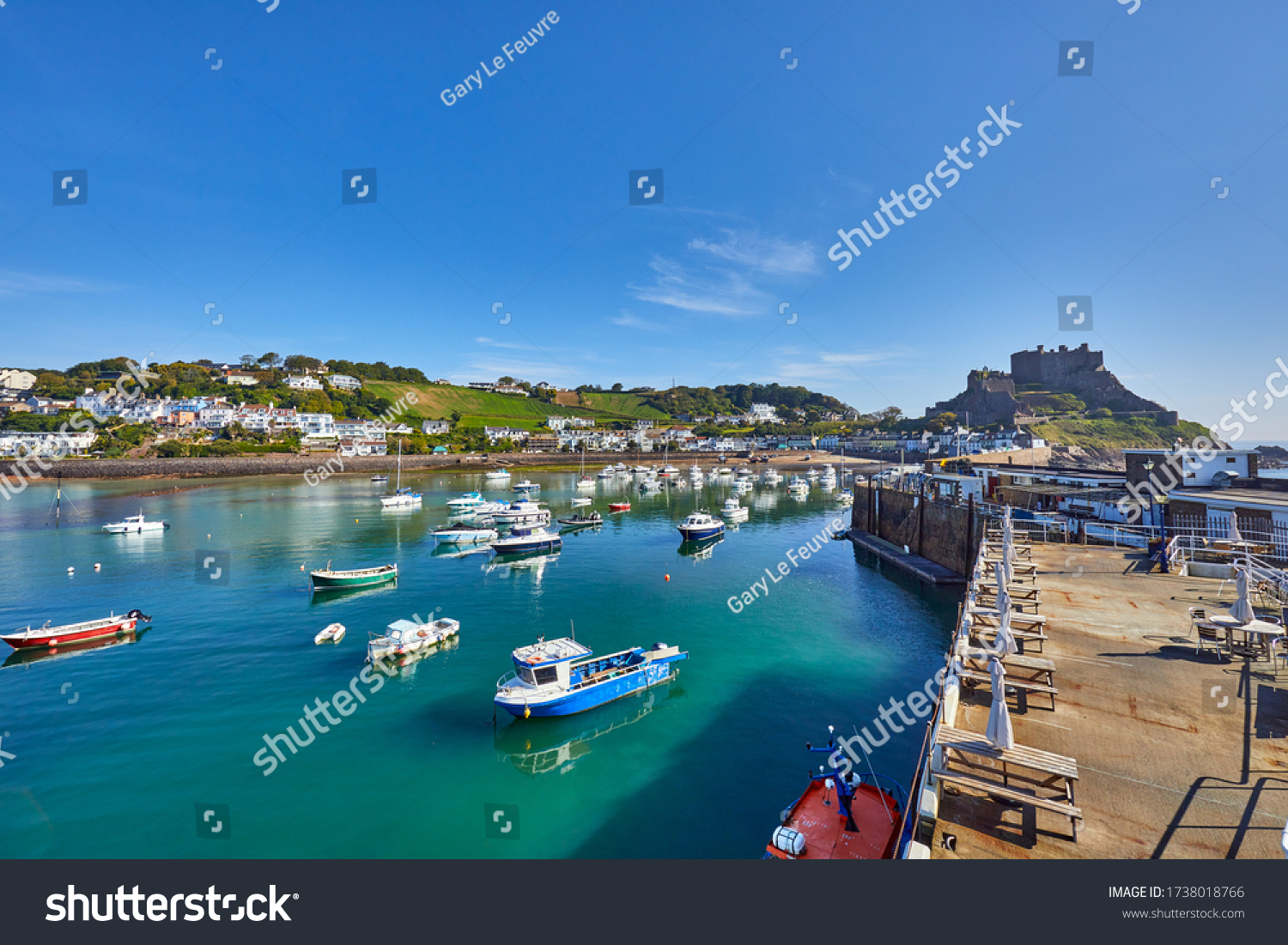 Image of Gorey Harbour with fishing and pleasure boats, the pier bullworks and Gorey Castle in the background with blue sky. Jersey, Channel Islands, UK #1738018766