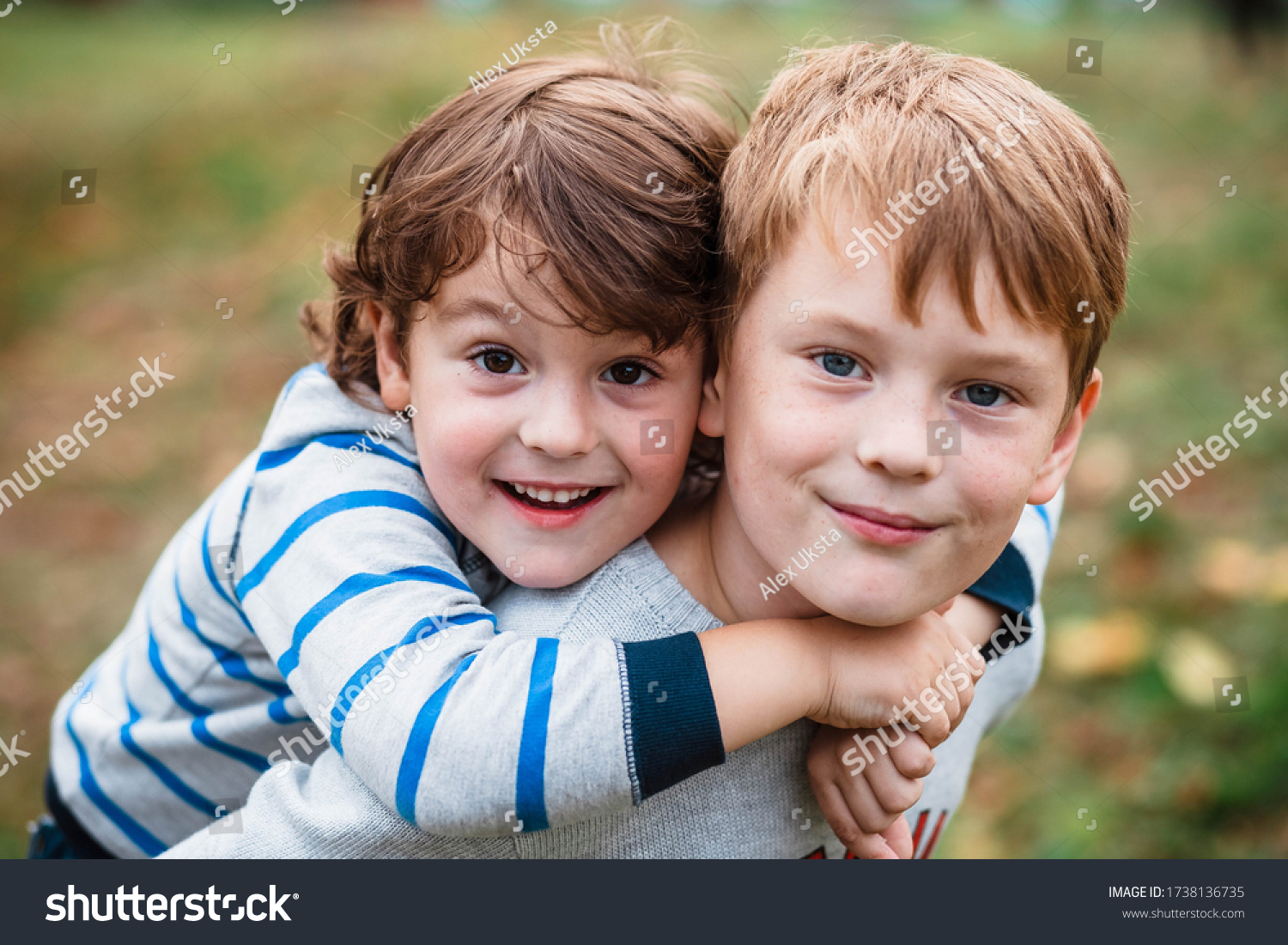 Two happy boys, happy brothers who are smiling happily together. Brothers play outdoors in summer, best friends. Little brother with brother on his back. Two brothers in the woods. Fraternal relations #1738136735