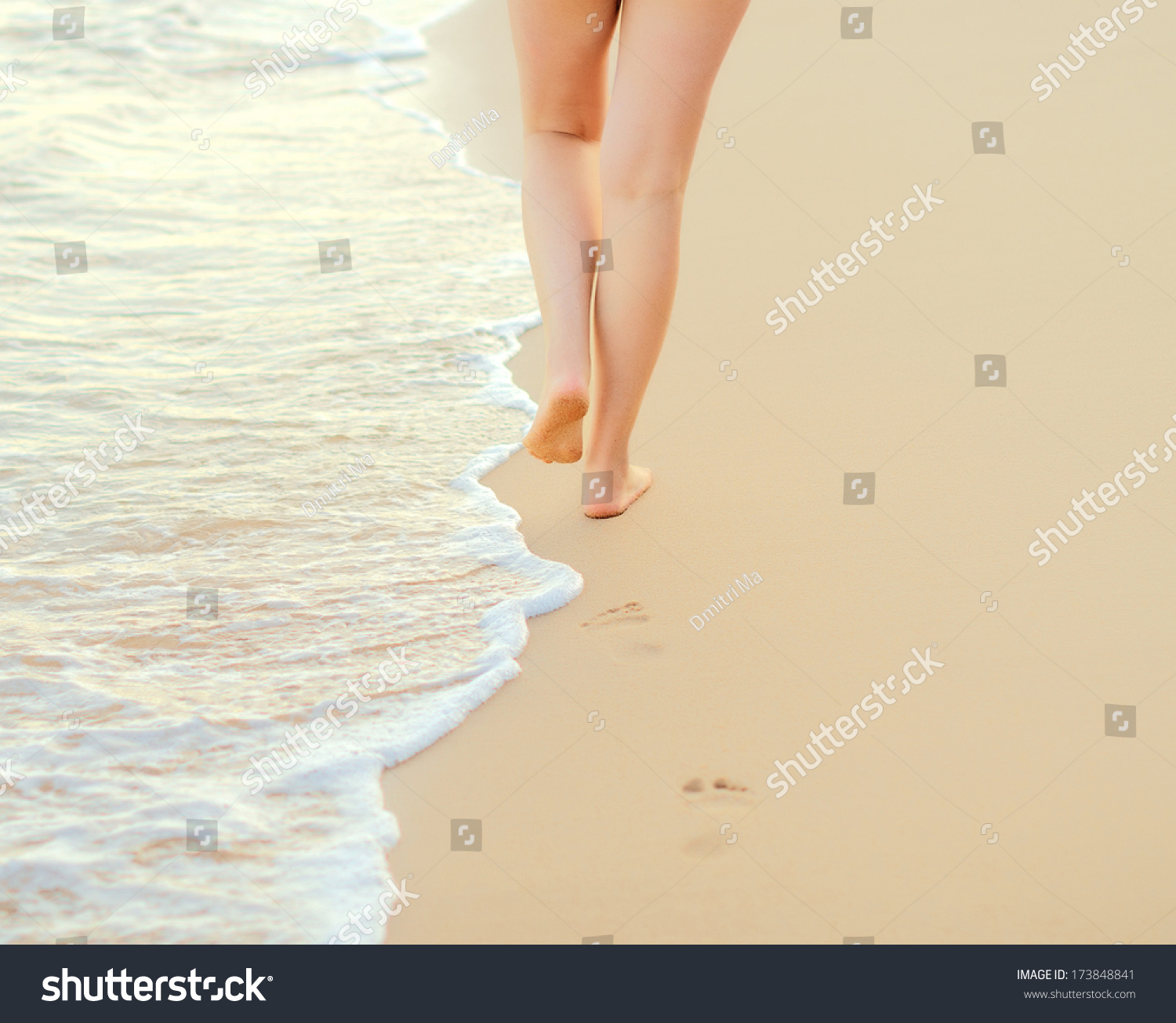 Pair of female legs on a seashore. #173848841