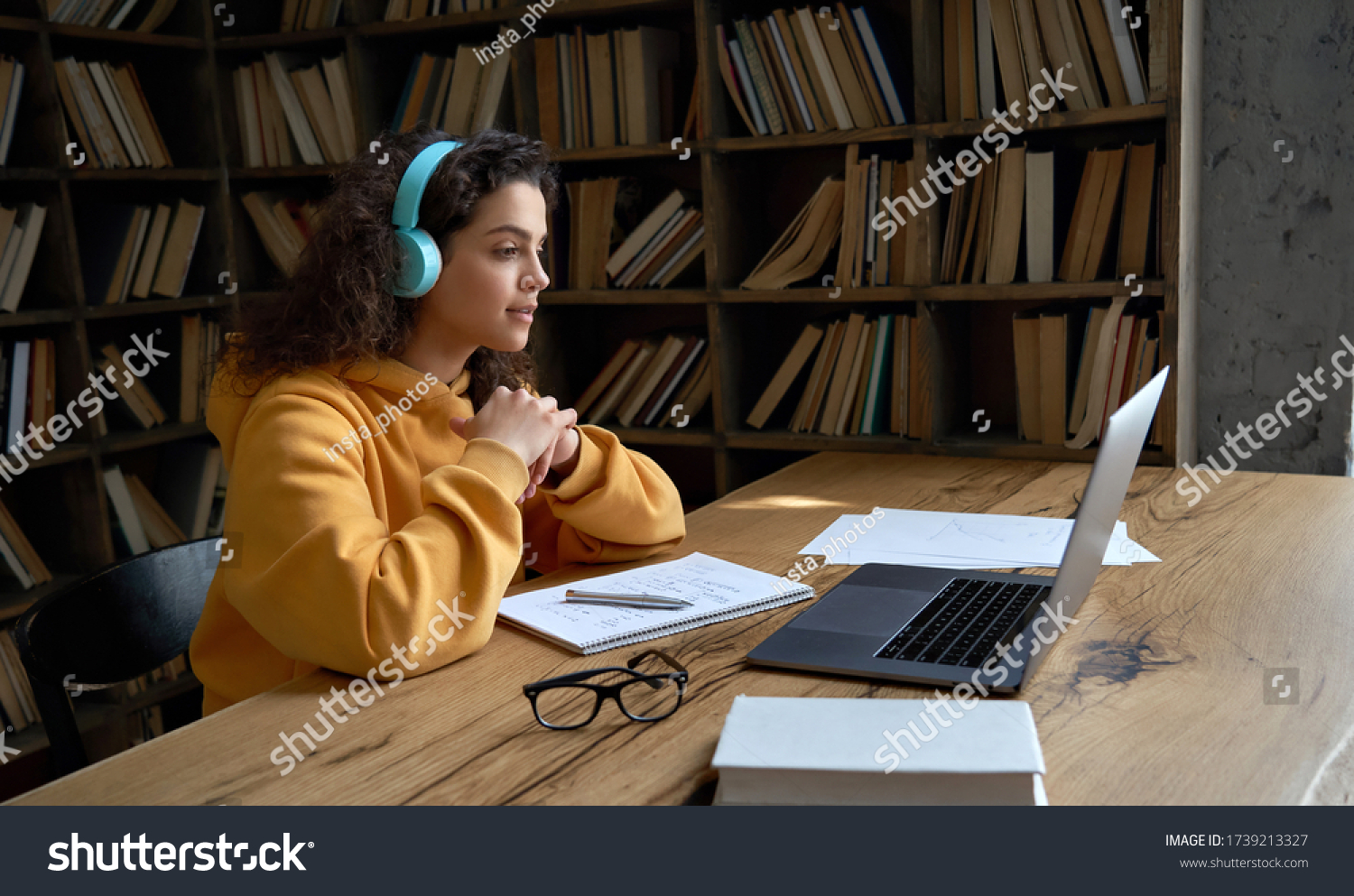 Hispanic teen girl, latin young woman school college student wear headphones learn watching online webinar webcast class looking at laptop elearning distance course or video calling remote teacher. #1739213327