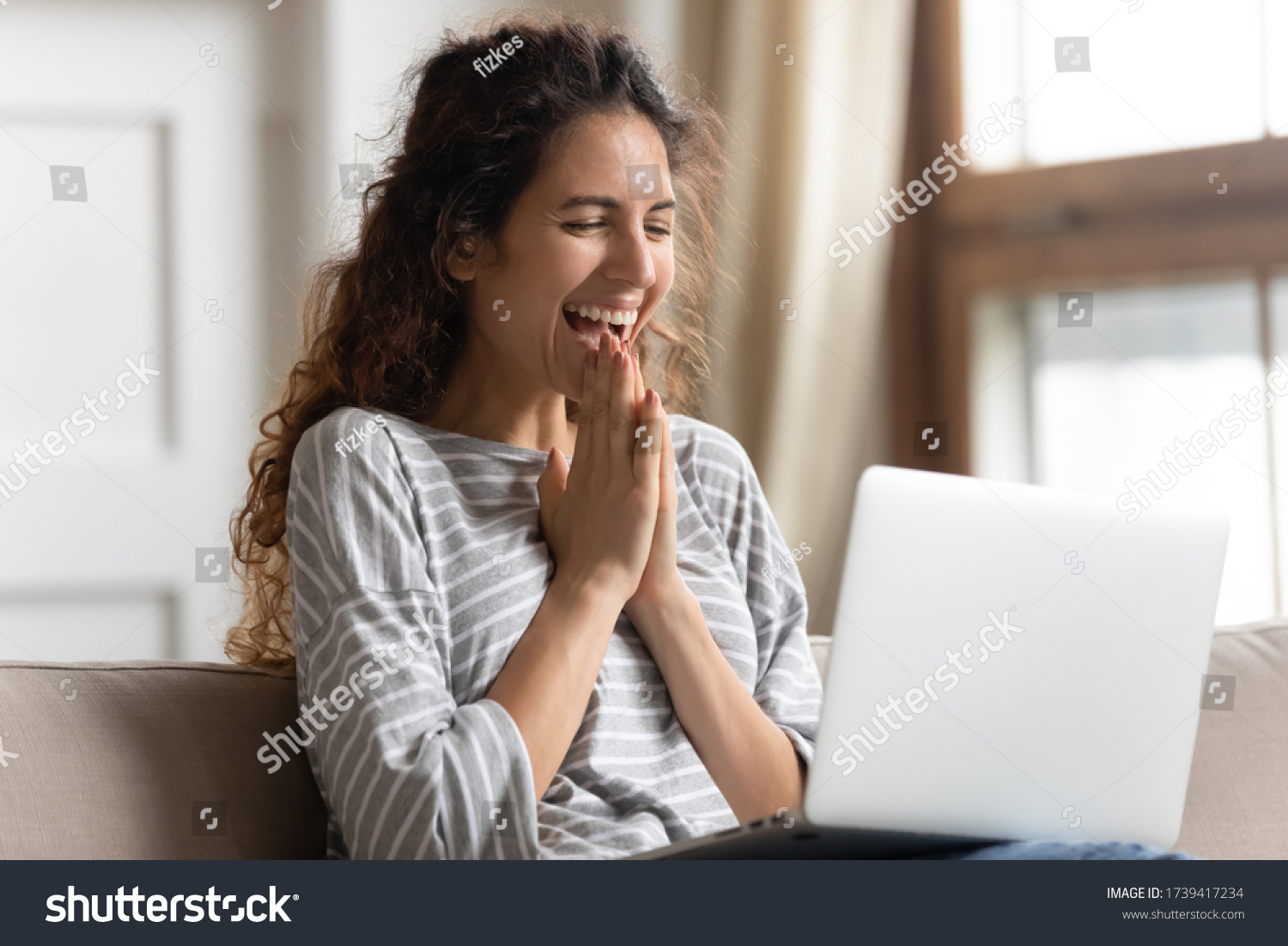 Excited woman looking at laptop screen, rejoicing good news, happy laughing girl reading email or message in social network, win online lottery, great shopping offer, sitting on cozy sofa at home #1739417234