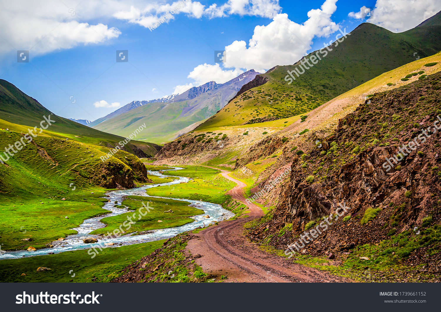 Road and creek in mountain river valley. Hill valley landscape #1739661152