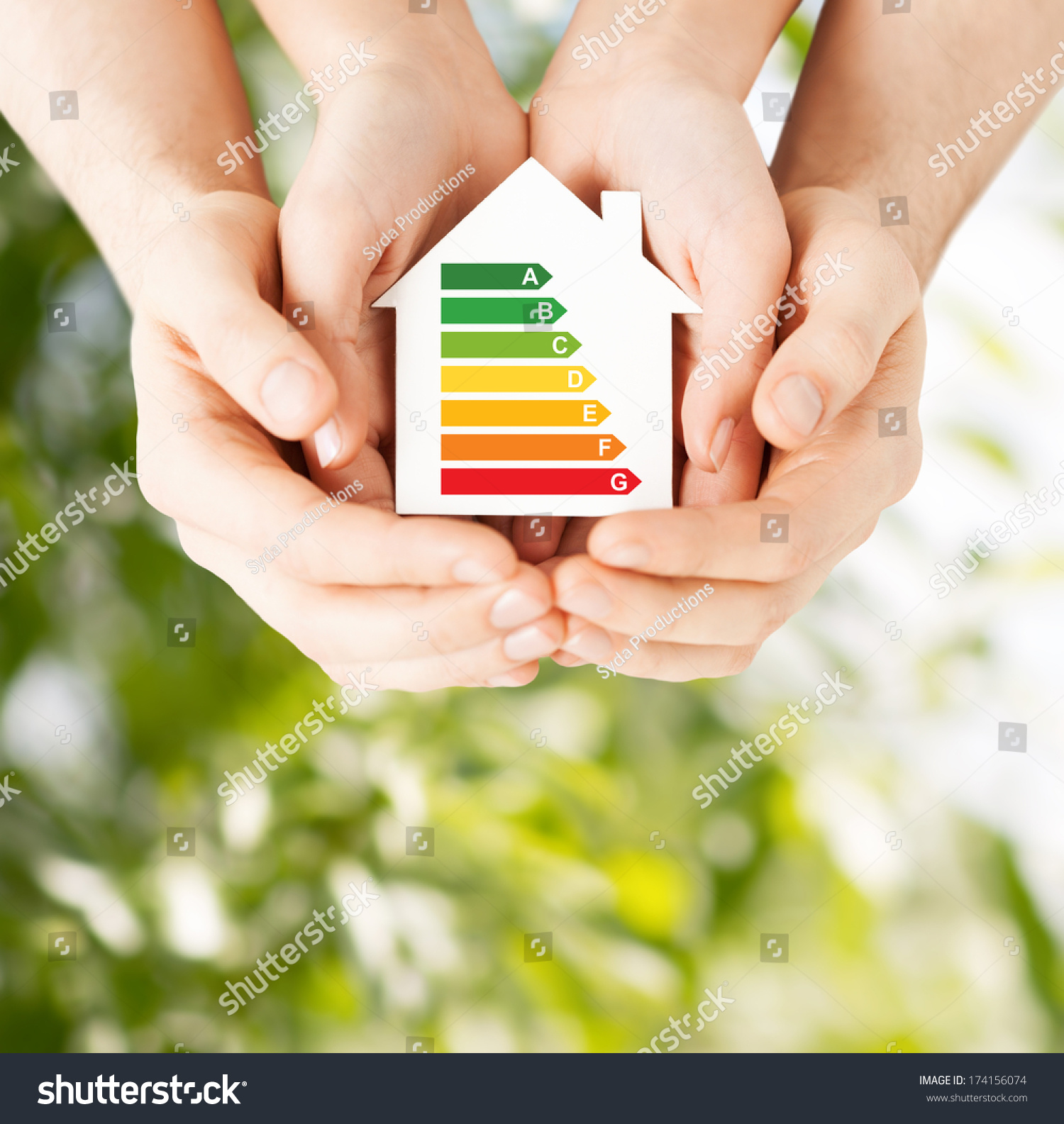 energy saving, real estate and family home concept - closeup of couple hands holding white paper house with energy efficiency rating #174156074