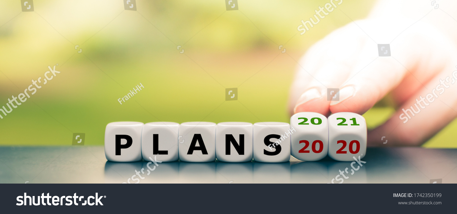 Hand turns dice and changes the expression "plans 2020" to "plans 2021" #1742350199