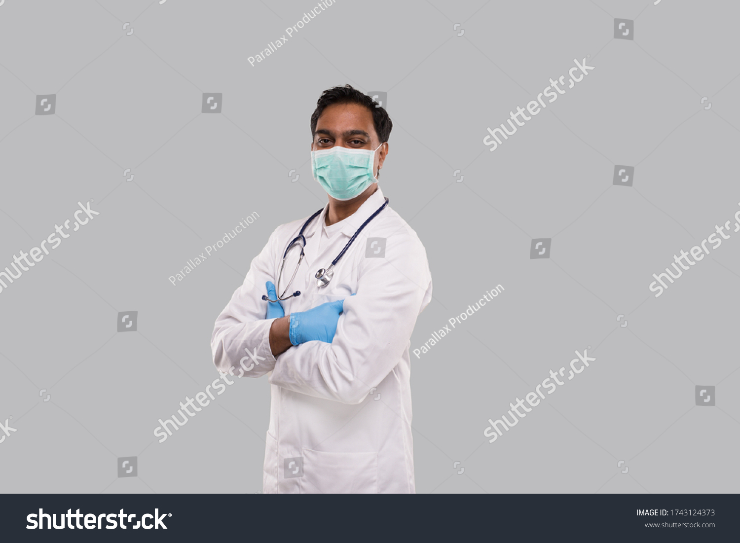 Doctor Wearing Medical Mask and Gloves Isolated. Indian Man Doctor Hands Crossed Medical Concept. Side View #1743124373