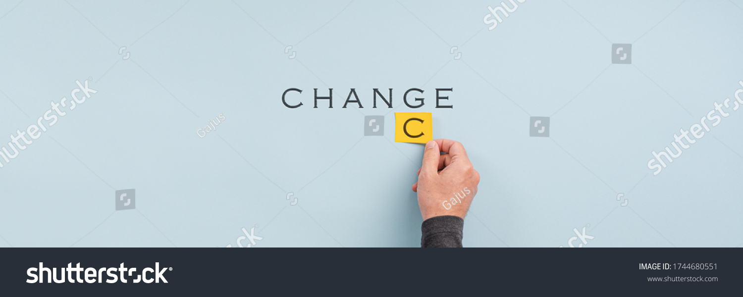 Wide view image of male hand changing the word Change into Chance in a conceptual image. Over light blue background with copy space. #1744680551