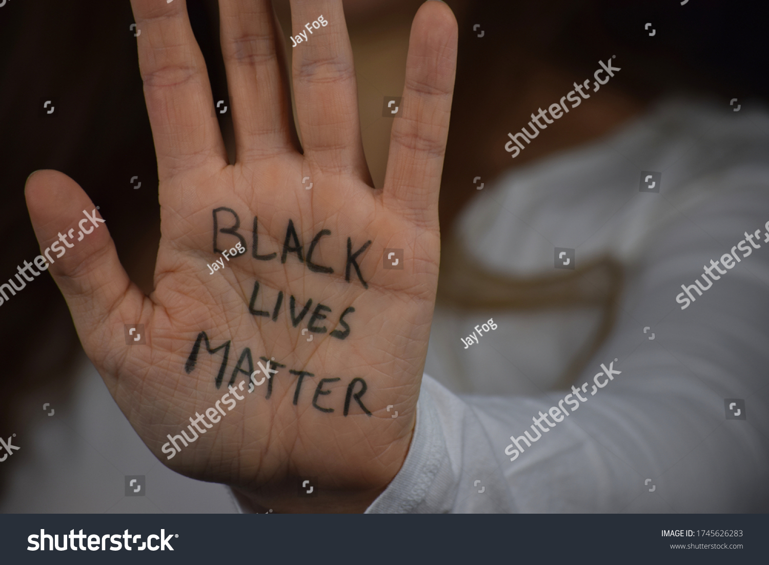 Black Lives Matter written on long haired white woman's hand. Caucasian girl  against racism and police brutality. Support to African Americans. #1745626283