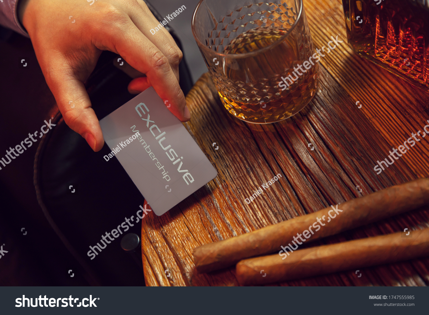 Man's hand puts exclusive membership card on the table. Gentleman's hand puts exclusive membership card on the wooden table with whisky in carafe and glass with cigars. #1747555985