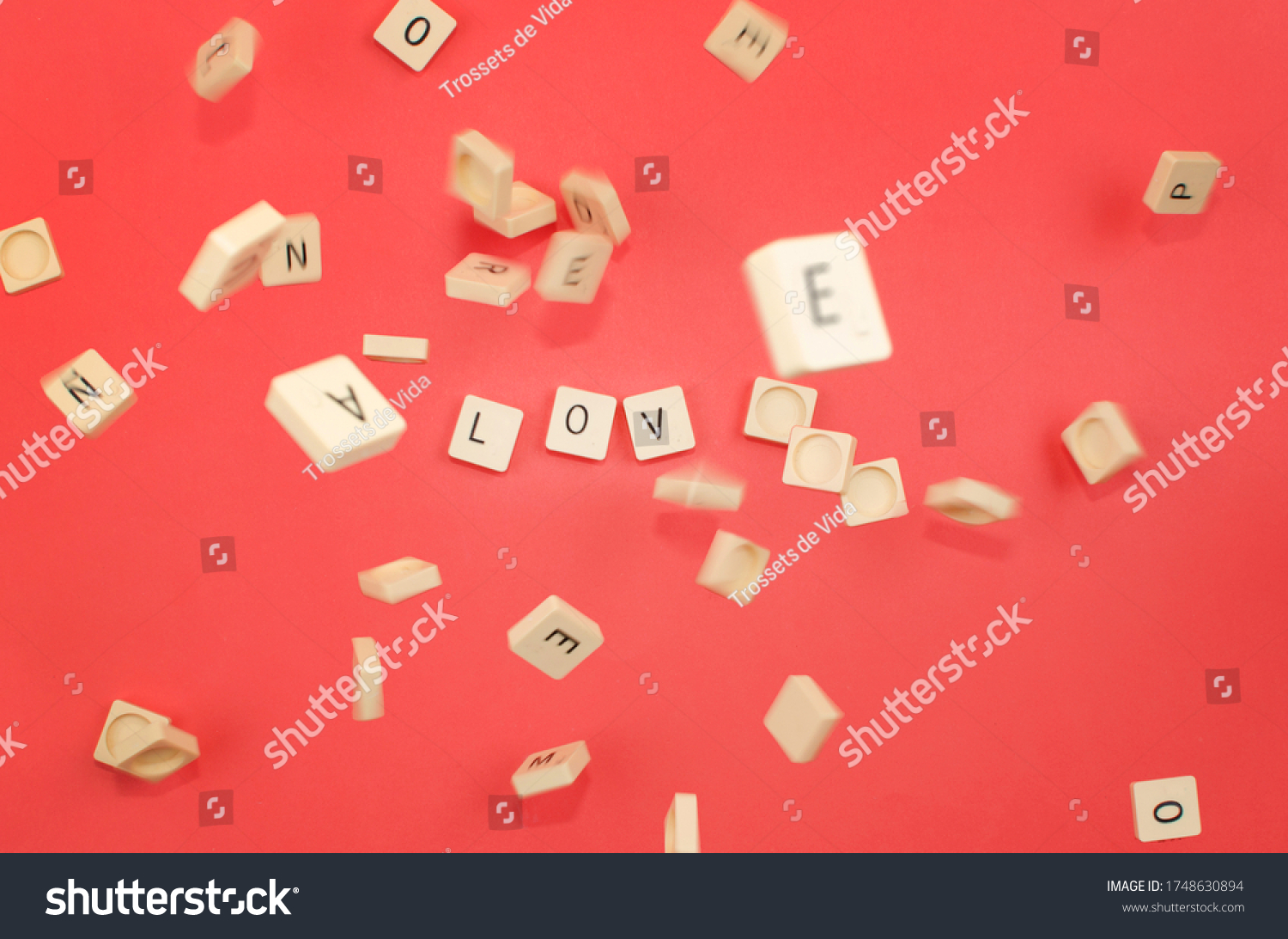red background with scrabble pieces with the word love and pieces falling #1748630894
